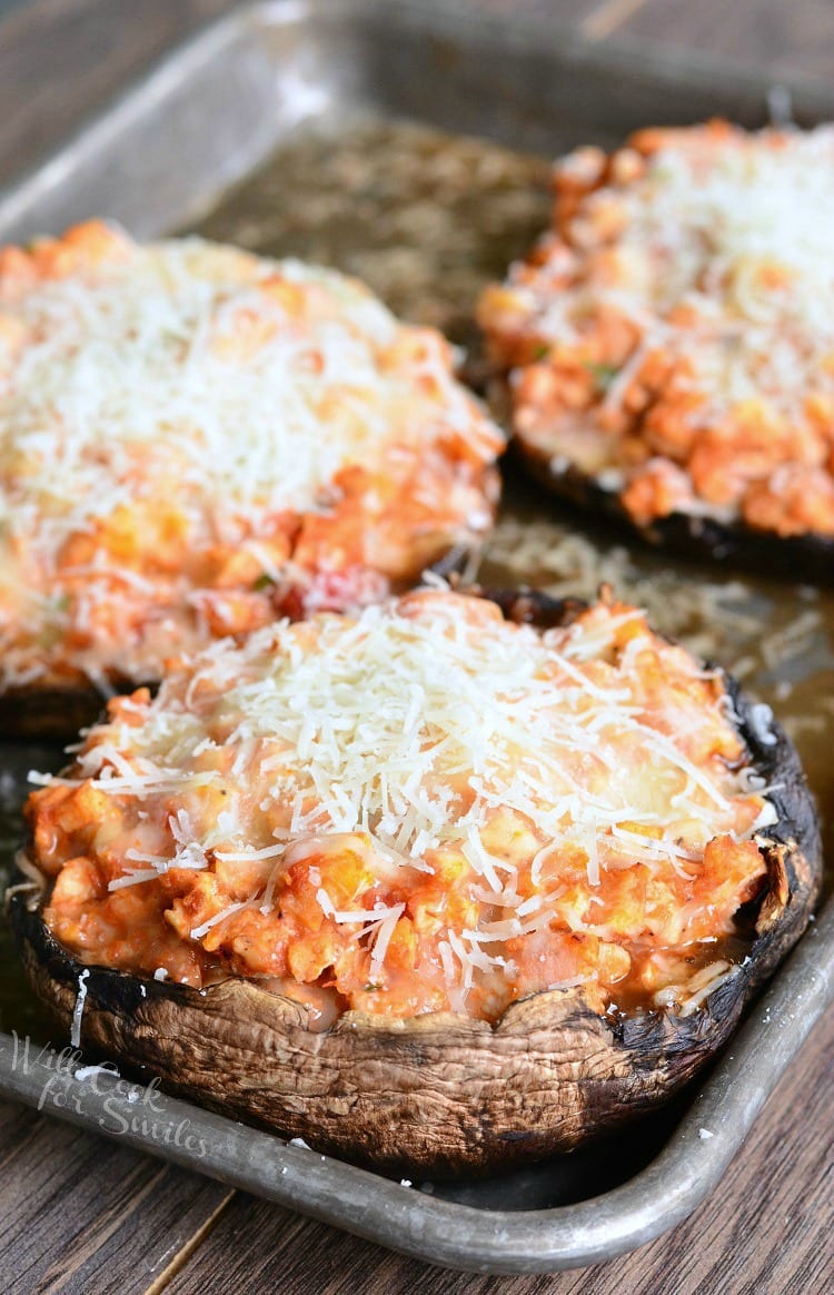 Chicken Parmesan Stuffed Portobello with cheese on top on a baking sheet