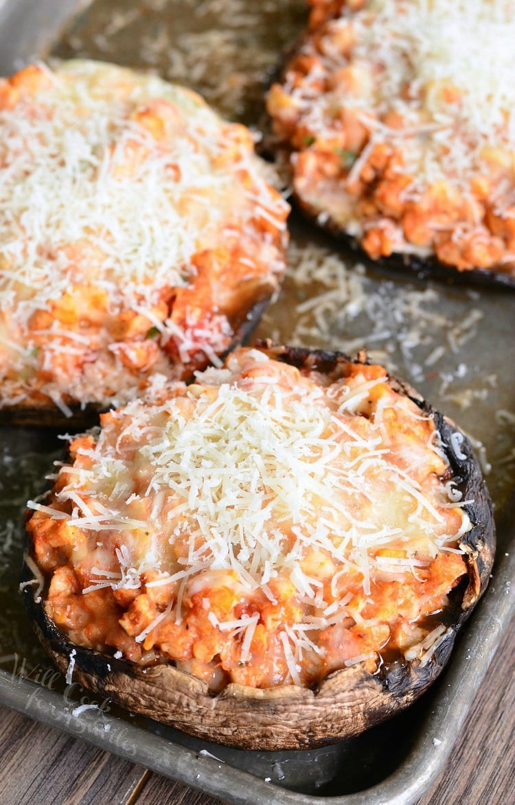 Chicken Parmesan Stuffed Portobello with cheese on top on a baking sheet