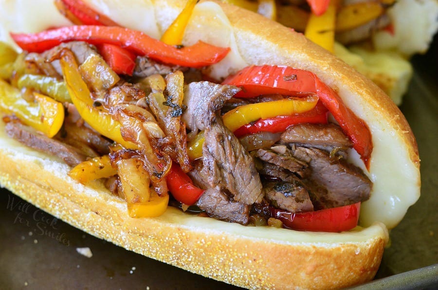 horizonal imagine of Fajita Philly Steak Sandwich with steak, red and yellow bell peppers, with onions on a hoagie roll