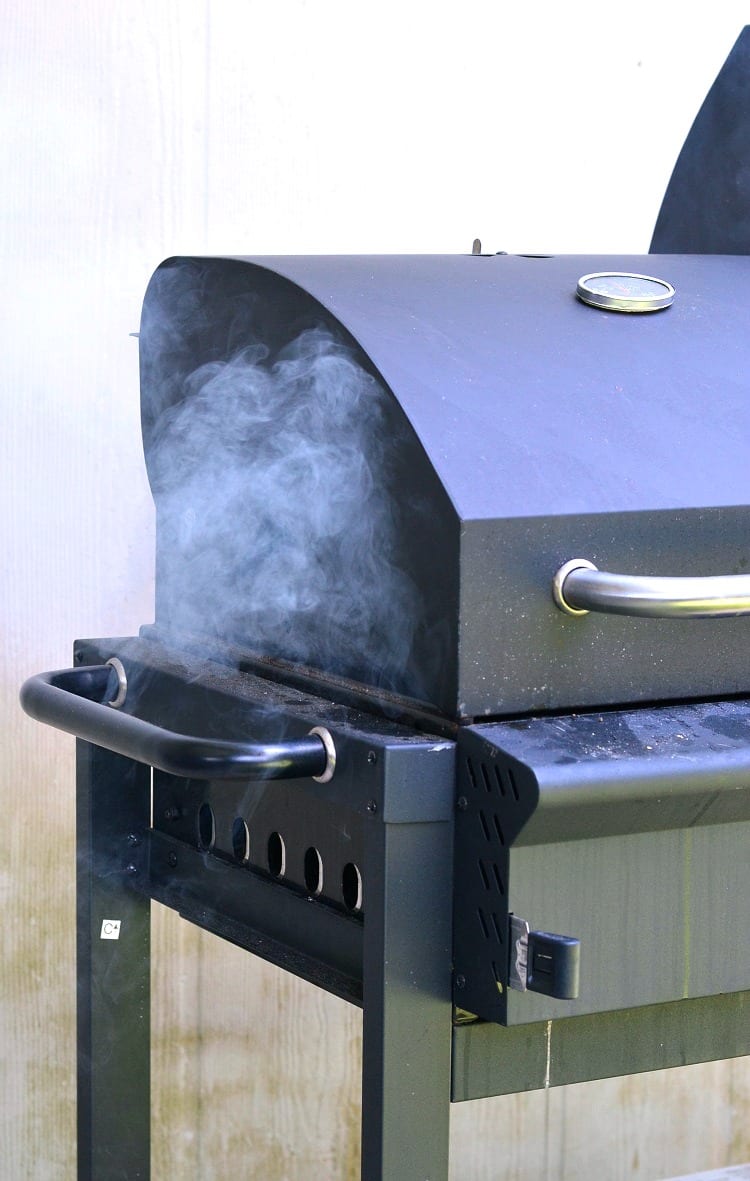 photo of black grill with smoke coming out of the side