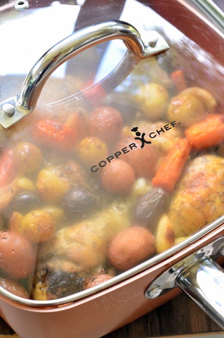 Chicken Drumsticks, garlic, potatoes, and carrots in a pan with the lid on top