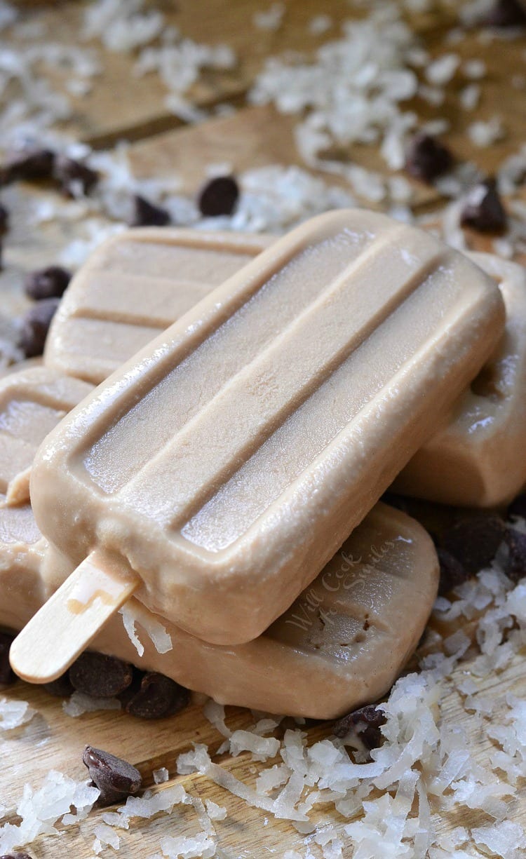 Coconut Mocha Ice Pops stacked up on a cutting board with coconut flakes