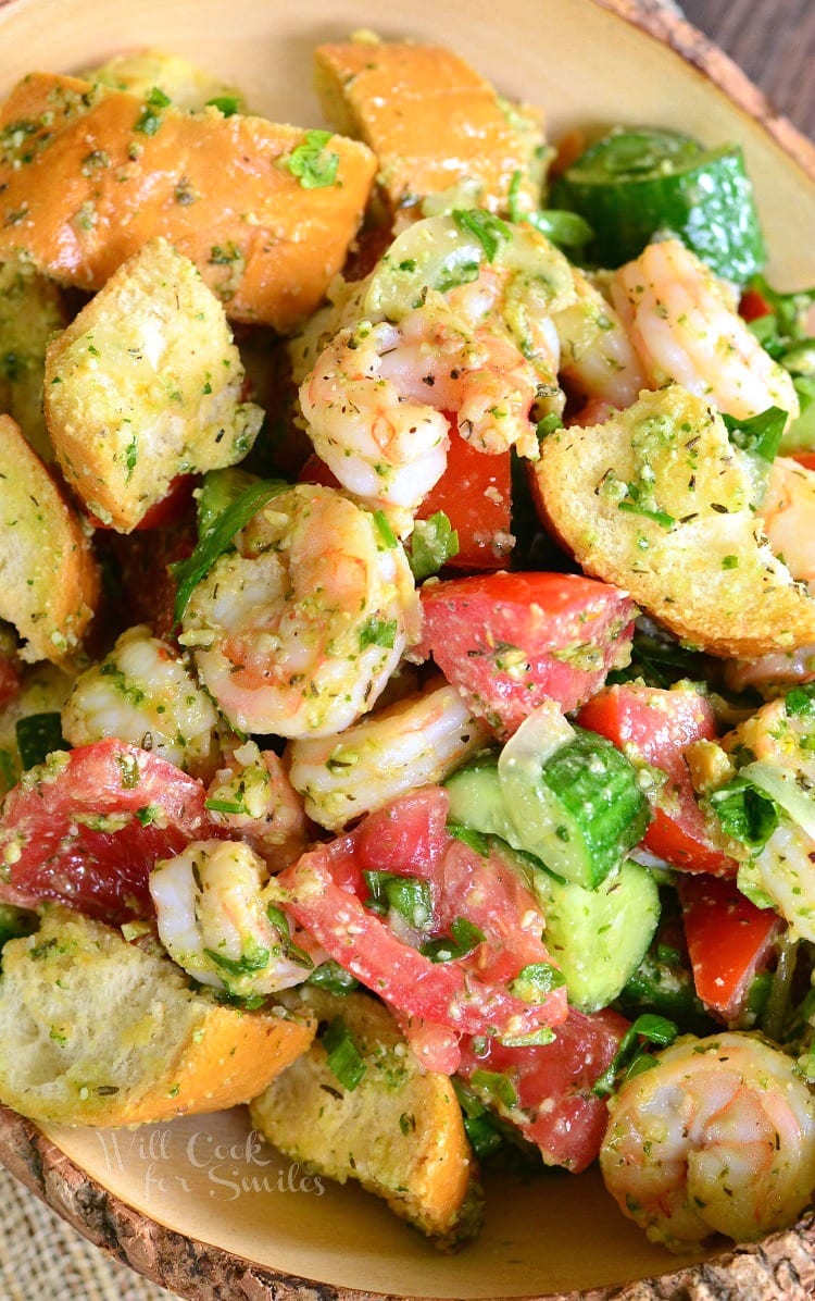 Top view Panzanella Salad with Shrimp, tomato, and cucumber, and bread with Pesto in a bowl