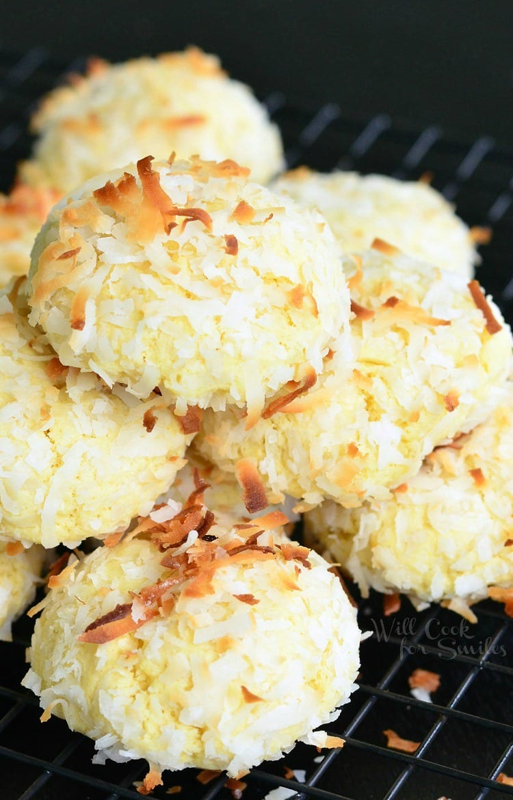 Coconut Pudding Cookies with coconut flakes on top stacked on a cooling rack
