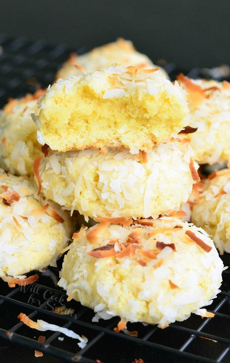 Coconut pudding cookies on a wire rack resting on a black table.