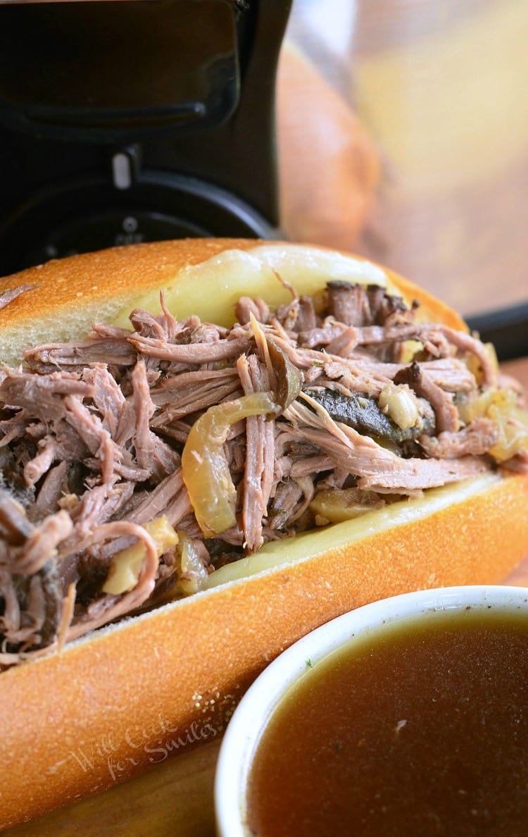 Mushroom and Onion Italian Beef sub with au jus sauce in a white bowl