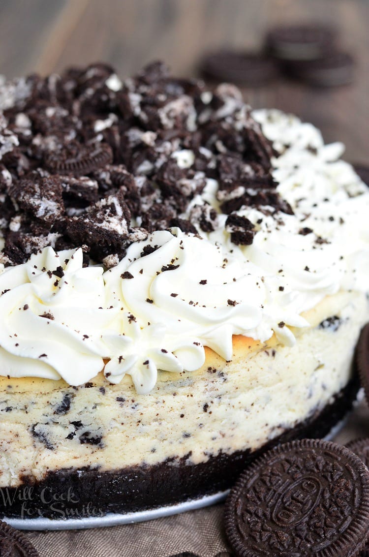 Oreo cheesecake on a table with oreo cookies to the right