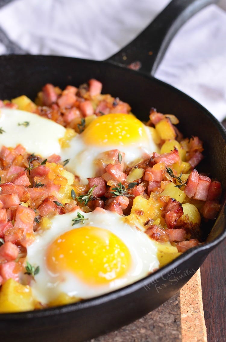 breakfast skillet filled with ham and potatoes and topped with eggs.