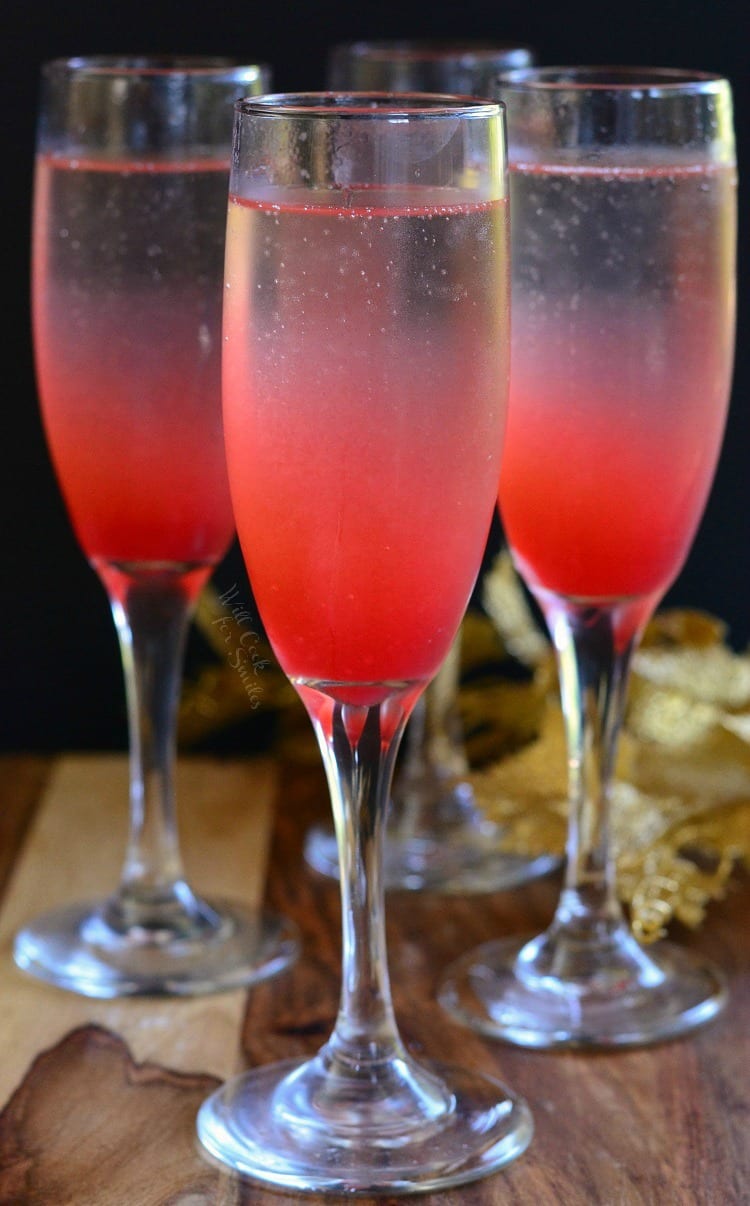 3 Raspberry Italian Soda Champagne Cocktail in a champagne flute on a table