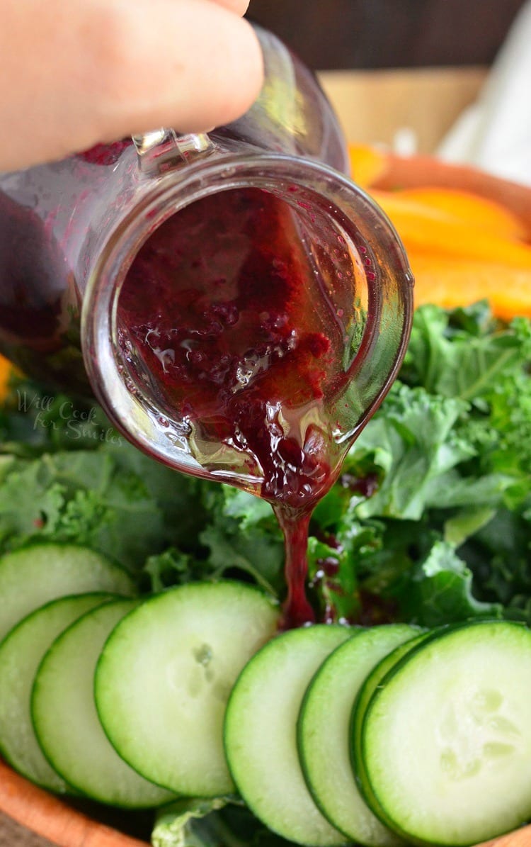 Blueberry Lavender Vinaigrette in a glass container being poured over a salad