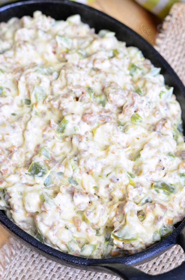 Top view of Cheesy Sausage Peppers and Onions Dip in a cast iron pan