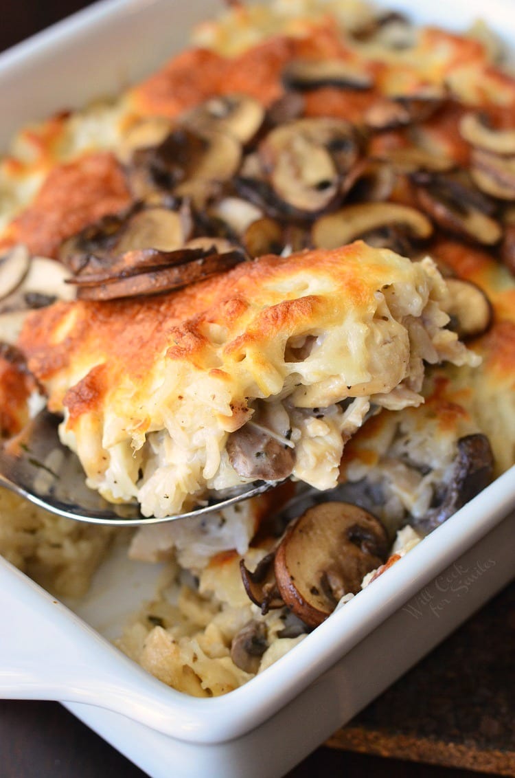 Creamy Chicken Mushroom Rice Casserole in a casserole dish with a spoon scooping some out