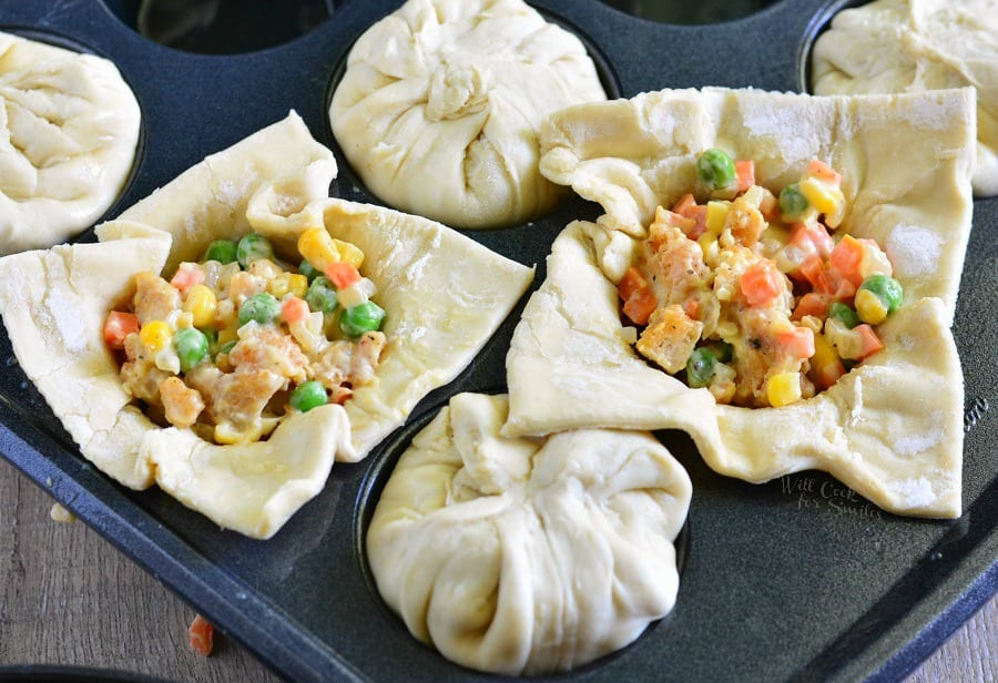 uncooked pie crust in a muffin pan with filling inside