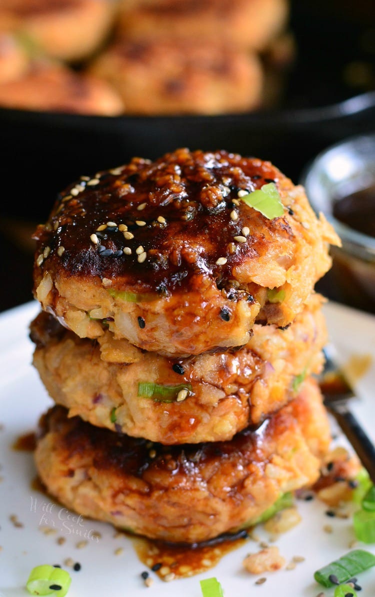 stacked cooked salmon patties topped with sauce