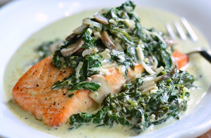 Horizonal salmon with Florentine and spinach and mushroom on a plate.