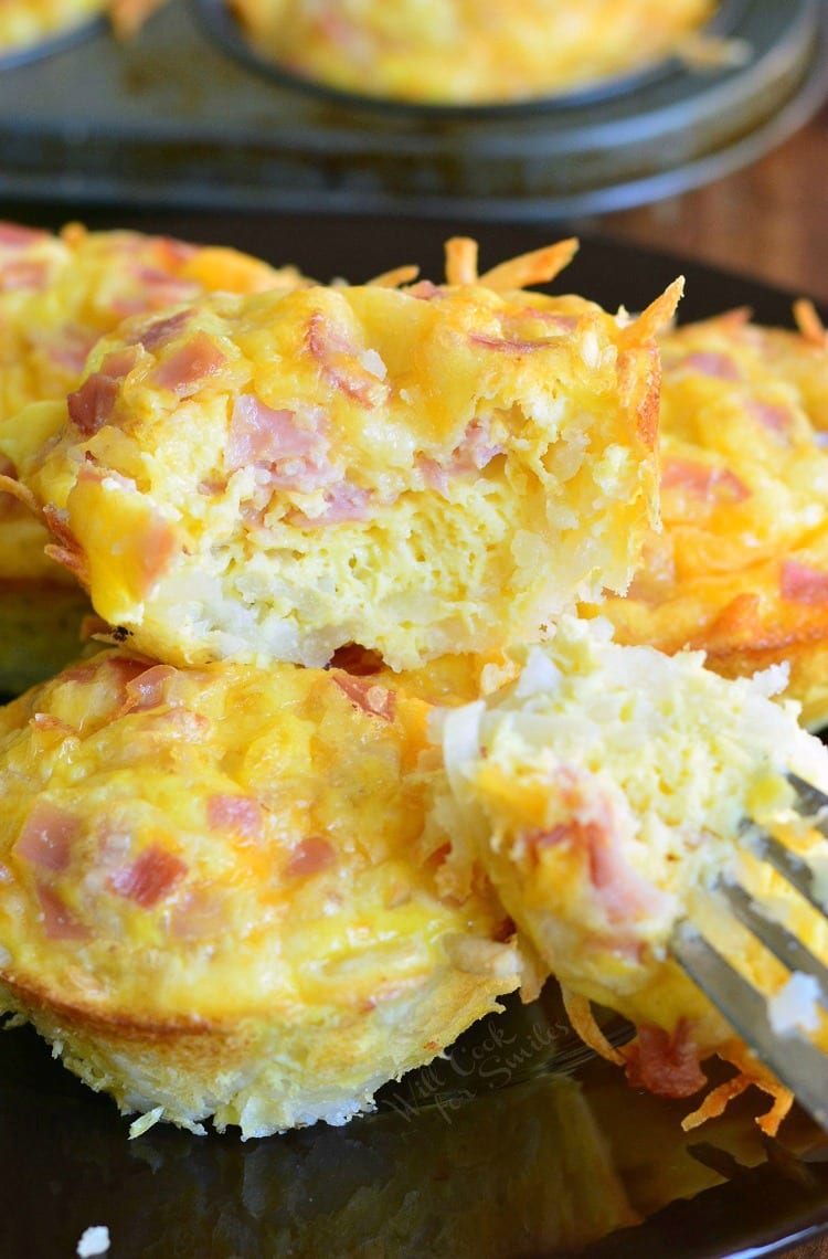 ham egg and cheese hashbrown breakfast muffin cut in half with a fork next to others.