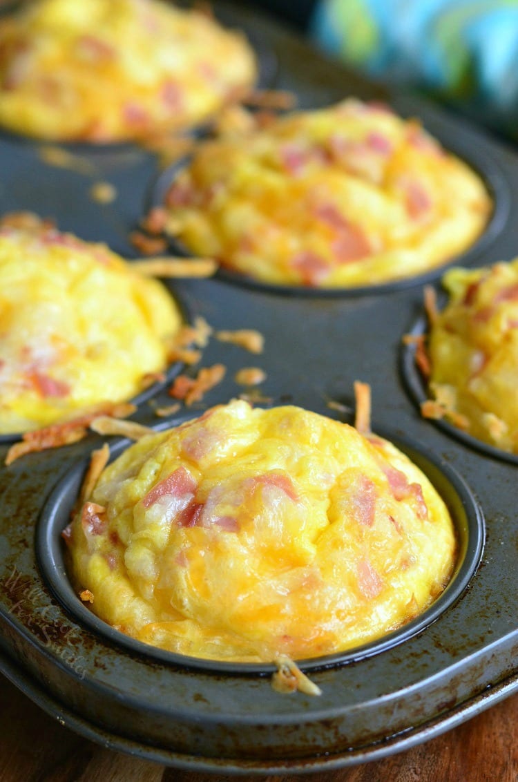 baked fluffy breakfast muffins with hashbrown, ham, and cheese in the muffin baking pan.