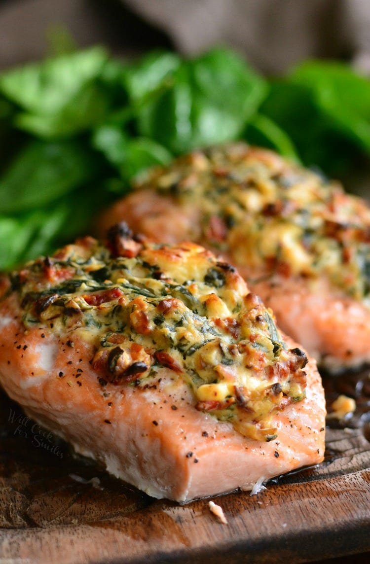 Creamy Spinach and Sun Dried Tomato Stuffed Salmon on a cutting board
