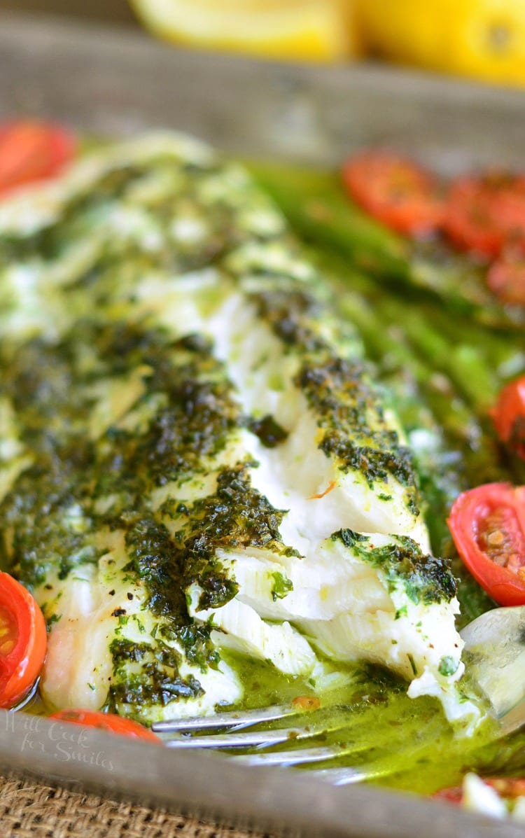 flaked baked cod with lemon herbs and butter and baked with asparagus and tomatoes.