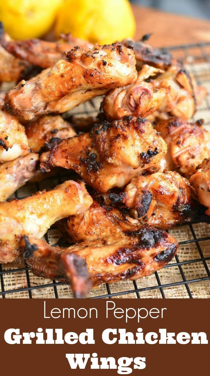 Grilled Chicken Wings stacked up on a cooling rack with lemons in the background