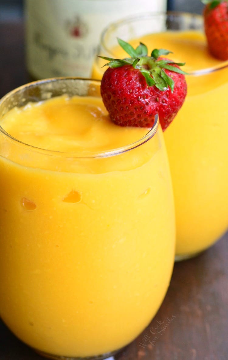 two mango champagne glasses filled with champagne.