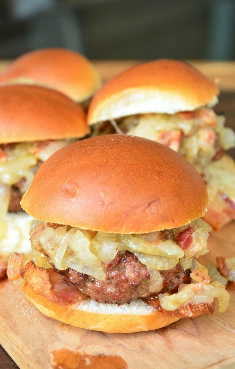 Bacon Burger Sliders with Bacon Caramelized Onions on a bun sitting on a cutting board