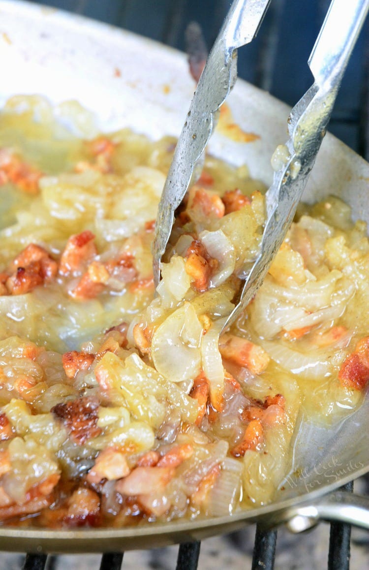 Grilled Bacon Caramelized Onions in a pan with tongs