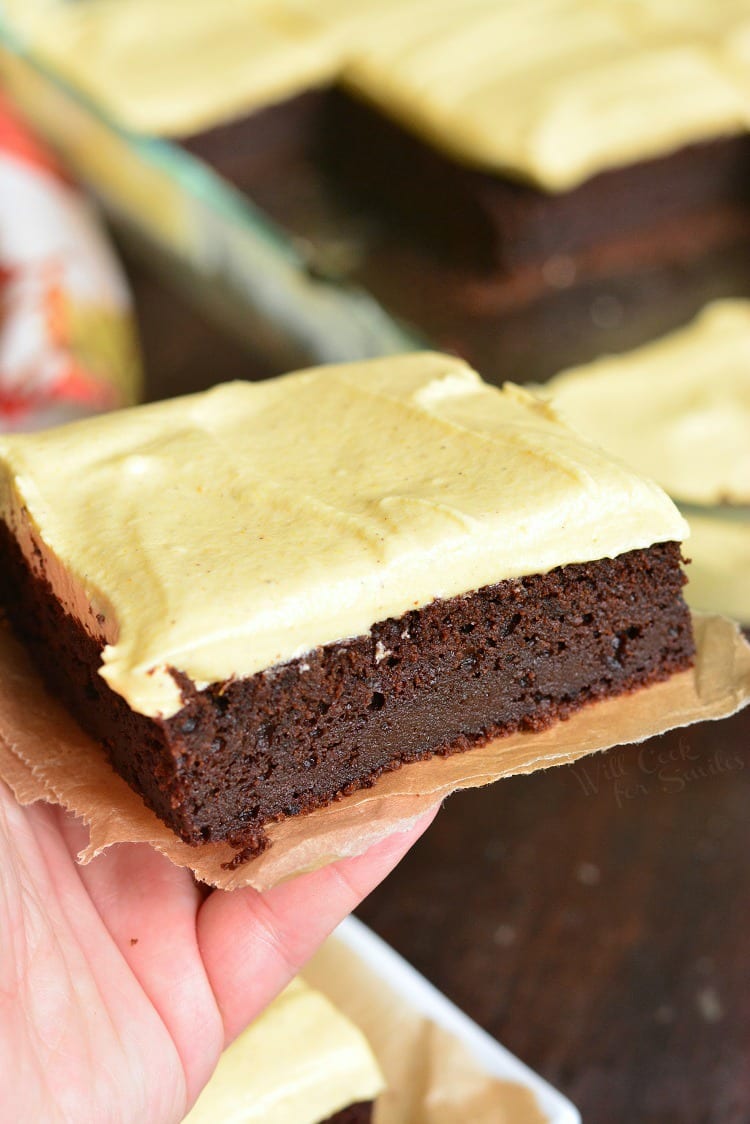 Frosted Pumpkin Brownies on parchment paper in my hand