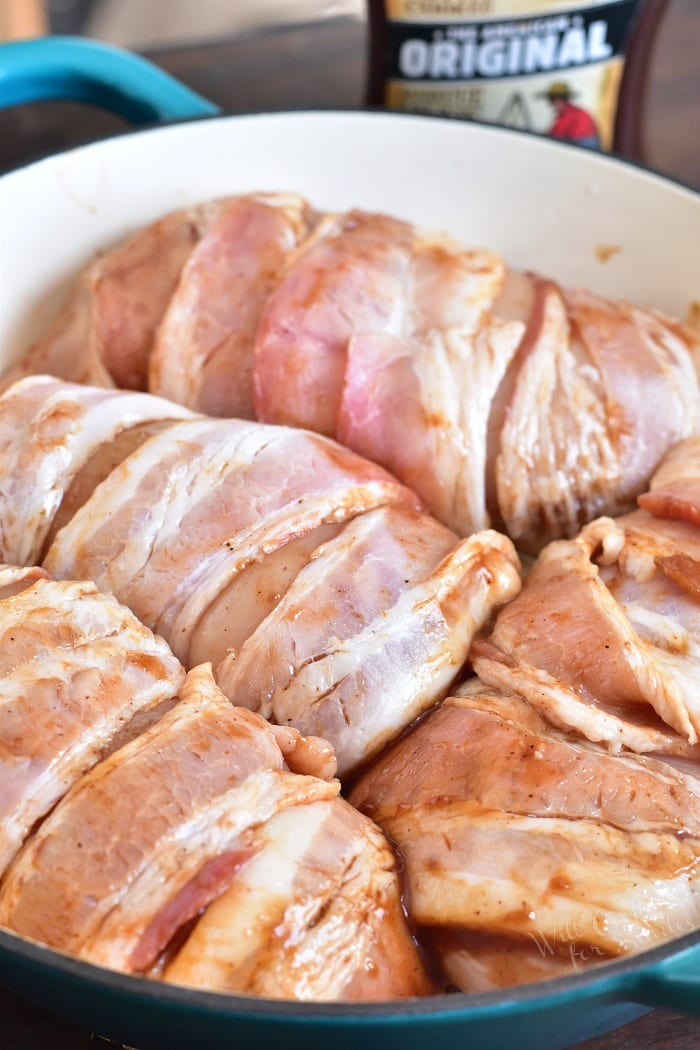 Raw Chicken Wrapped in bacon in a pan