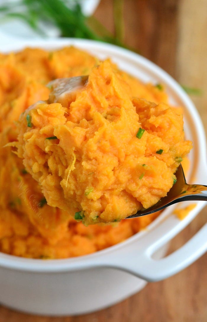 Mashed Sweet Potatoes in serving bowl being scooped out with a serving spoon