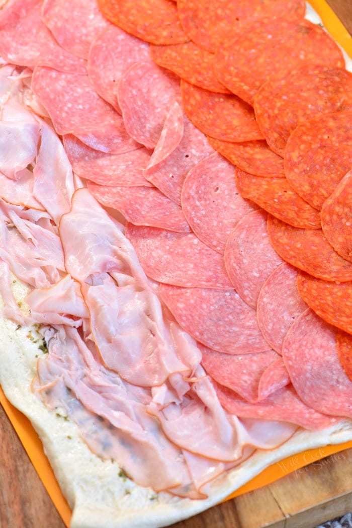 Layer ham, salami, and pepperoni over pizza dough in one even layer.
