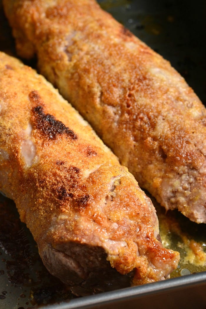 two cooked oven roasted pork tenderloins in the roasting pan.