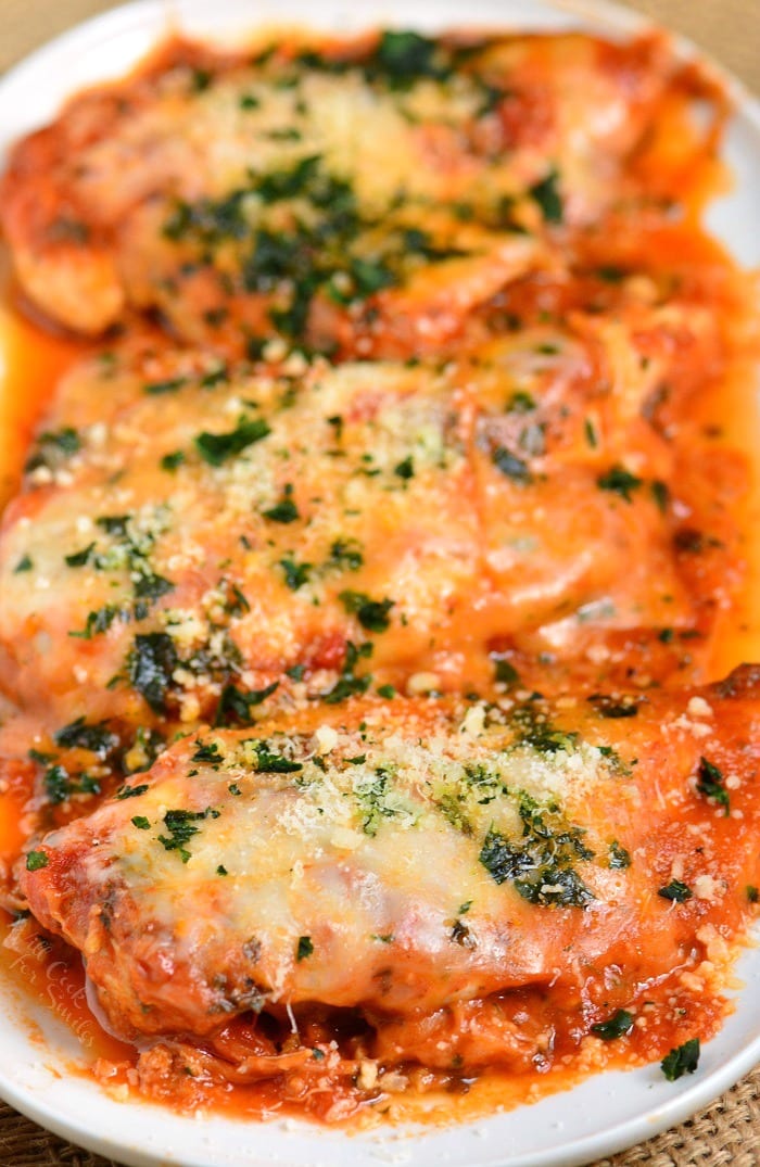 three cheesy and light instant pot chicken parmesan breasts in a plate.
