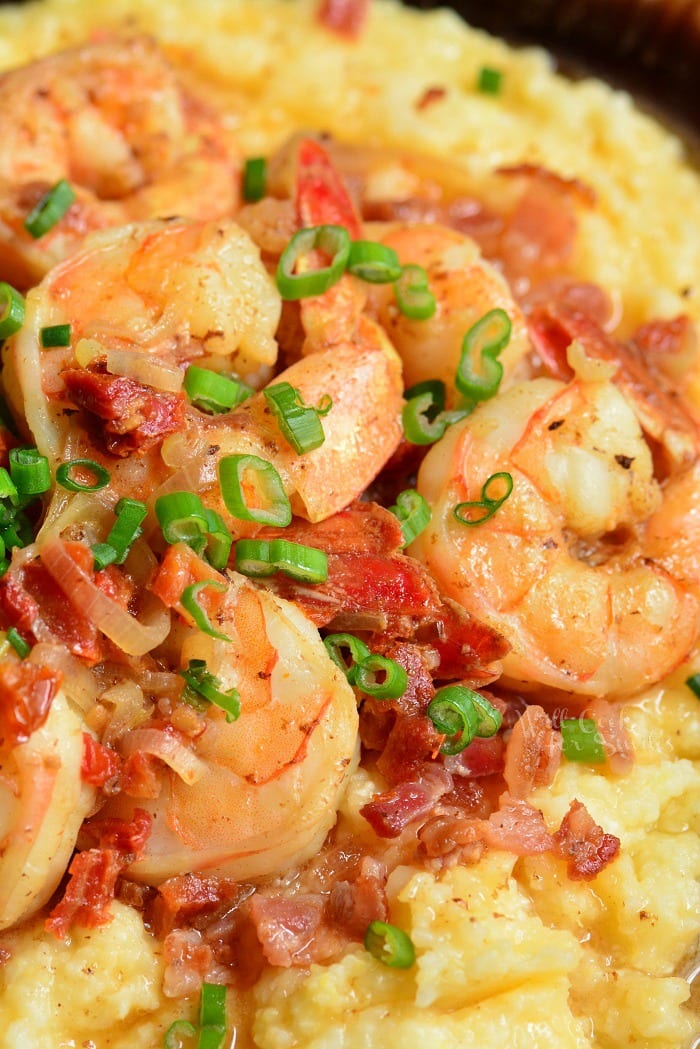 Shrimp and grits close up photo with bacon and green onions.