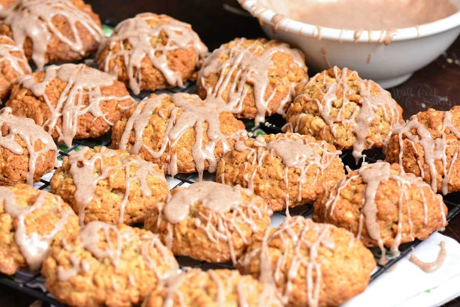 Soft and Chewy Oatmeal Cookies on a cooling rack with frosting in a bowl