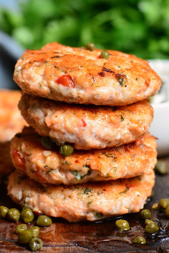 four salmon patties are stacked on top of each other.