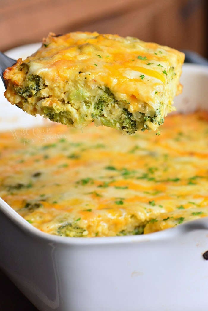 taking out a slice of broccoli cheese hashbrown casserole from the baking dish.