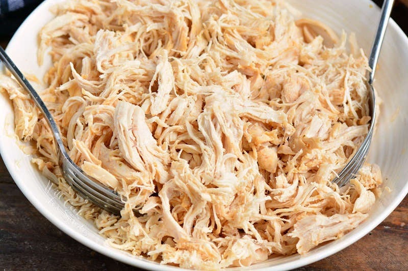 shredded chicken in a bowl with 2 forks
