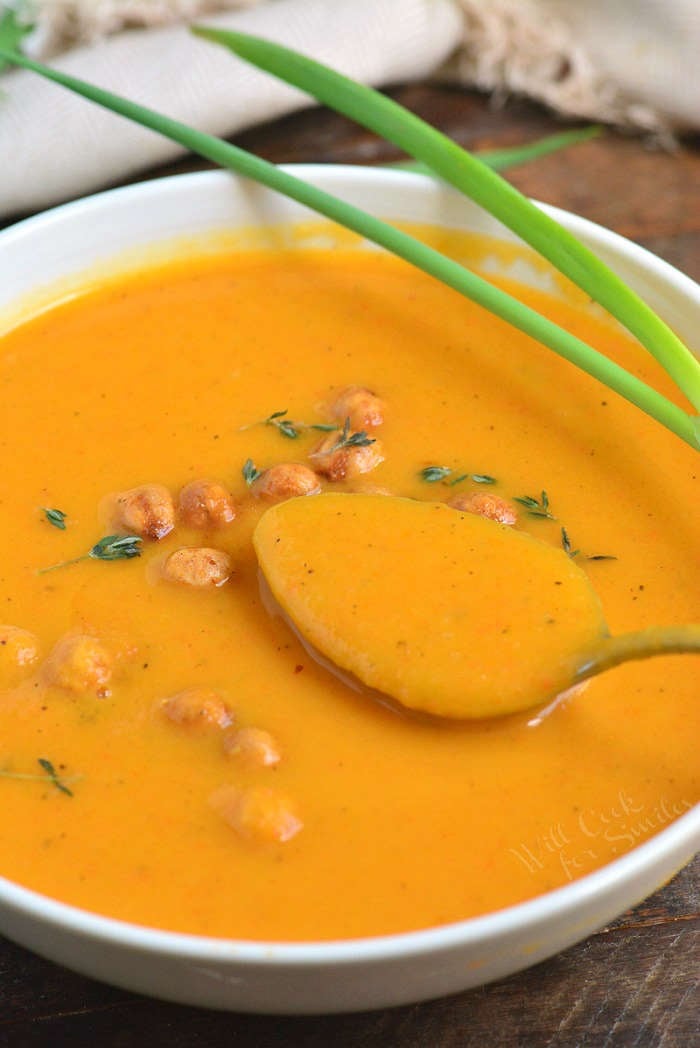 Spoonful of butternut squash soup that is in a bowl
