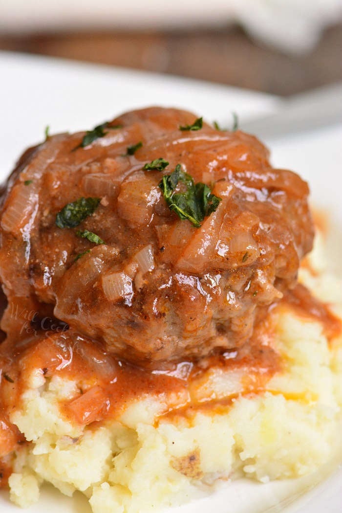large and juicy French onion Salisbury steak on top of fluffy mashed potatoes.
