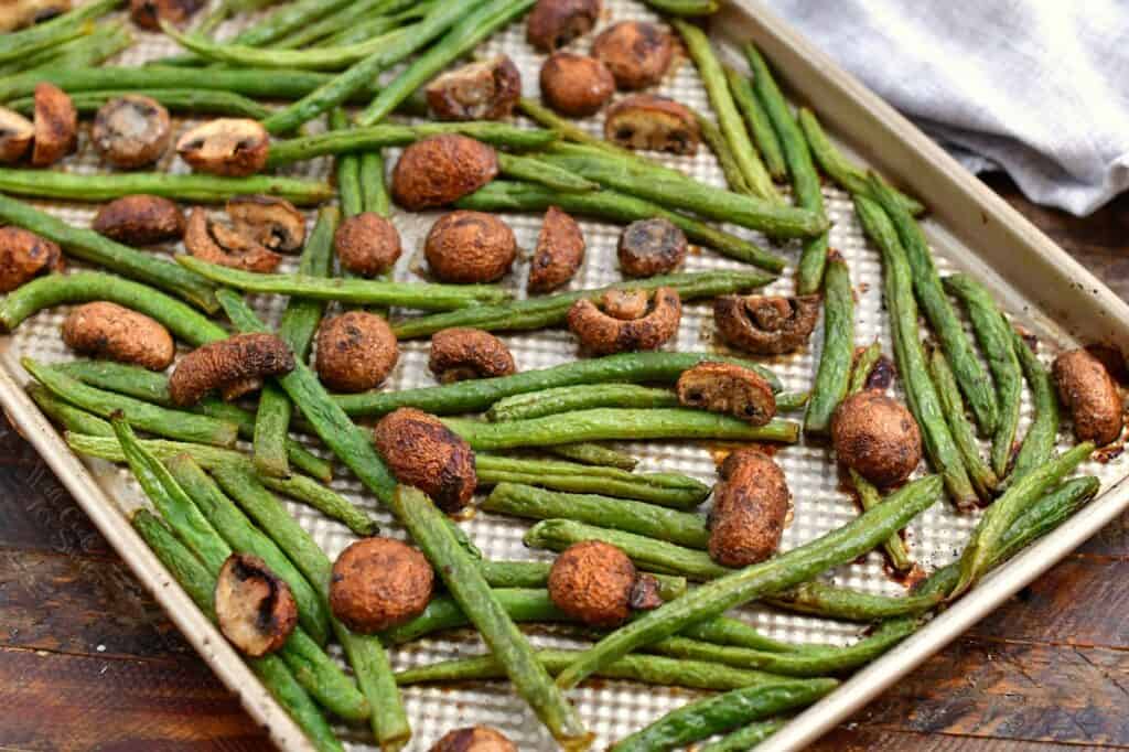 roasted green beans and mushrooms on rimmed baking sheet