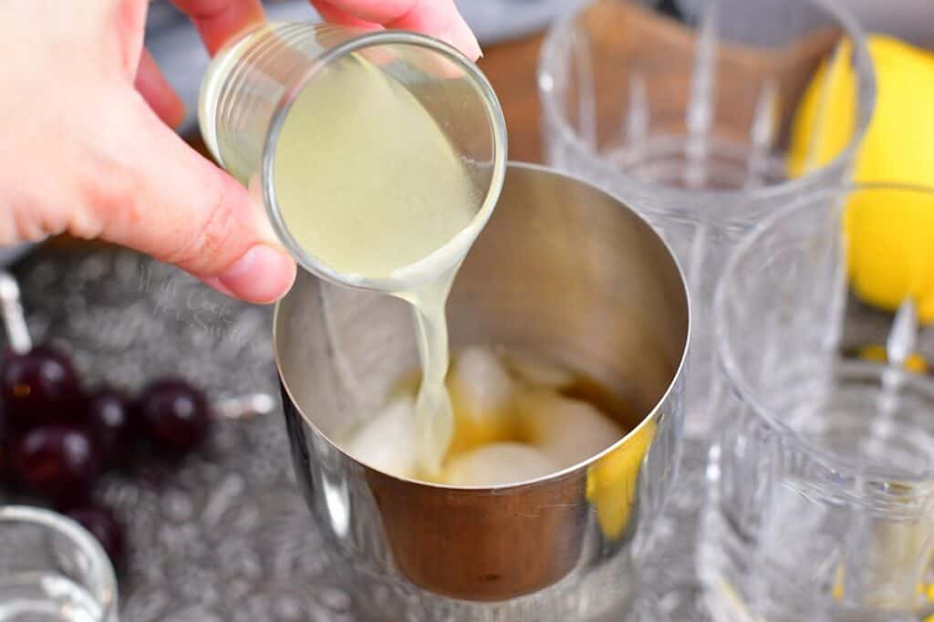 Lemon juice is being added to the cocktail shaker.