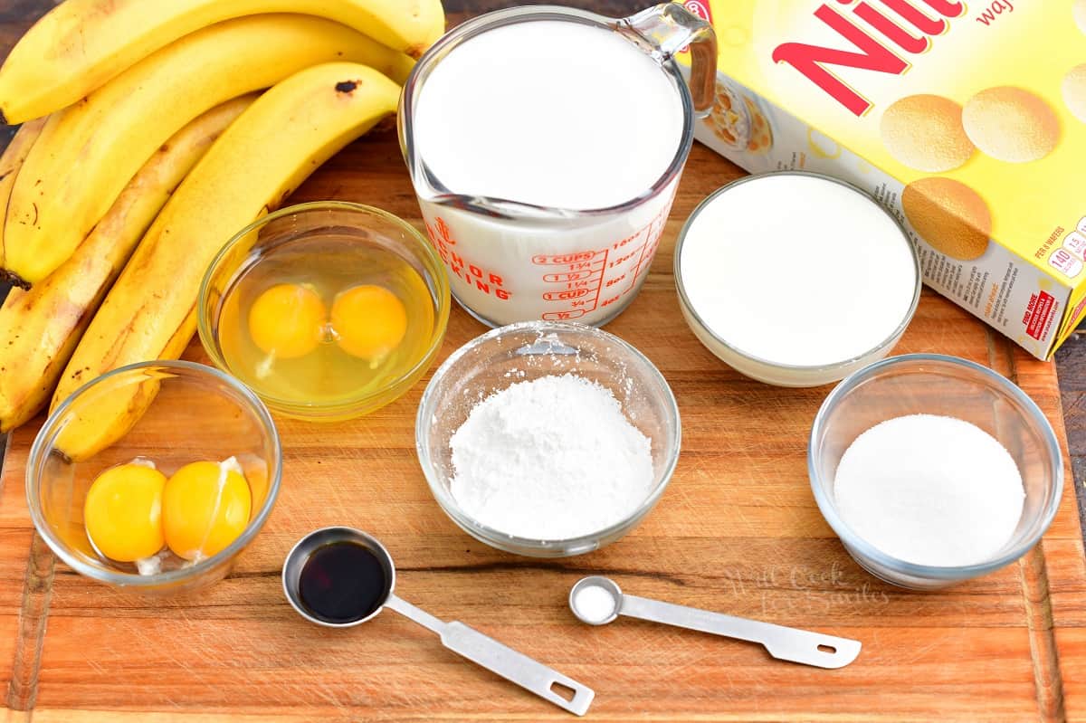 The ingredients for banana pudding are placed on a wooden surface.