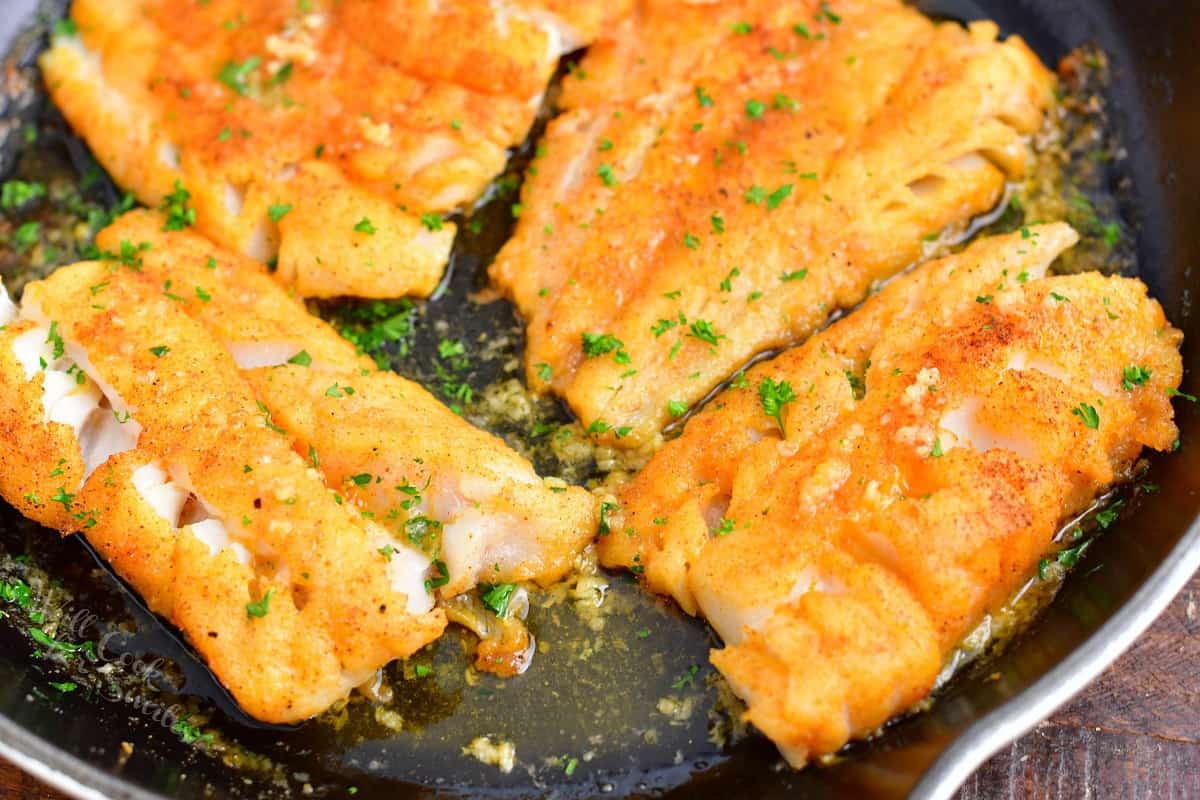 Parsley is garnishing cod filets.