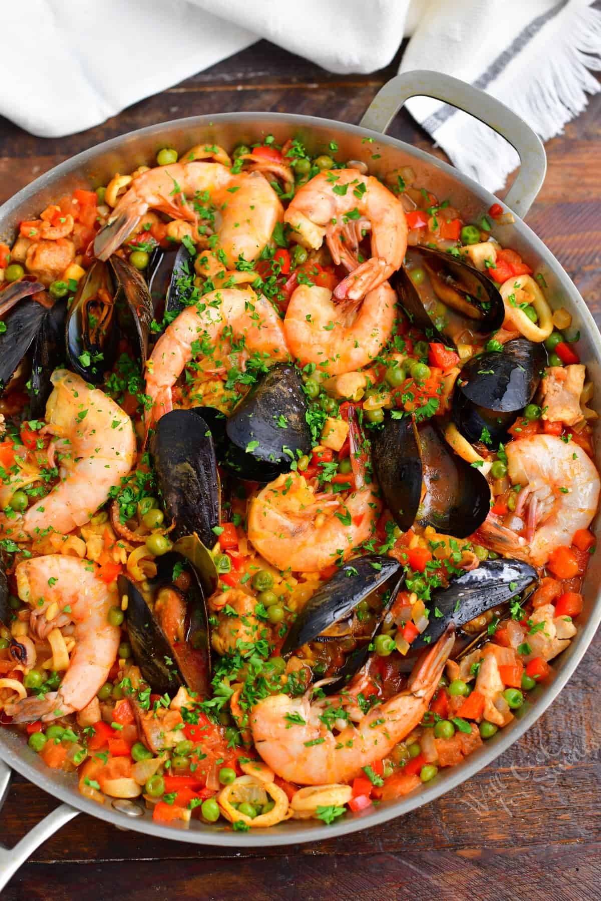 A large pan is filled to the brim with freshly cooked paella.