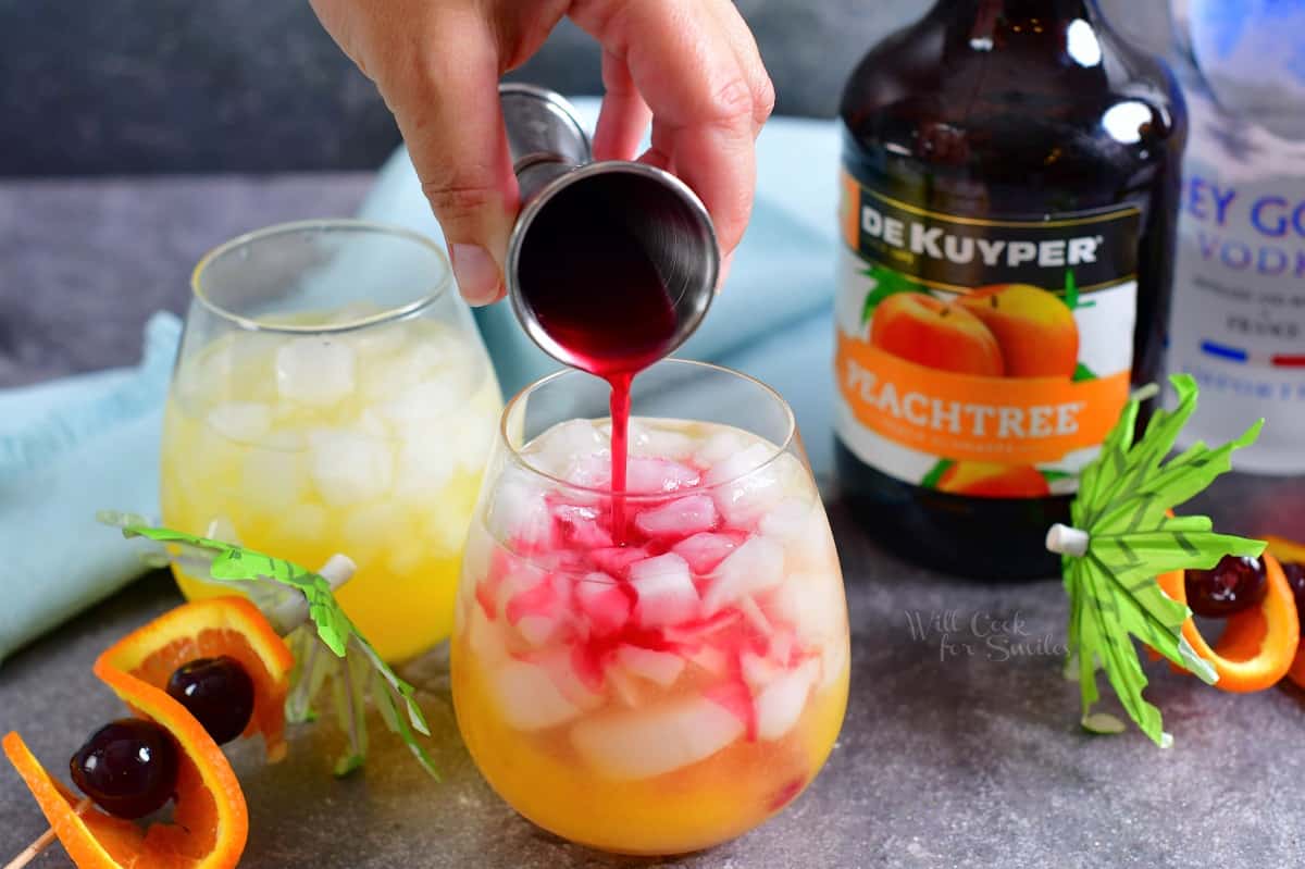 Cranberry juice is being poured into the glass.