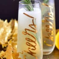 closeup of the tall glass with champagne cocktail and rosemary stick