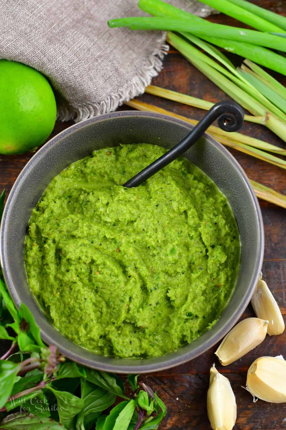 top view of green curry paste in a bowl with ingredients around