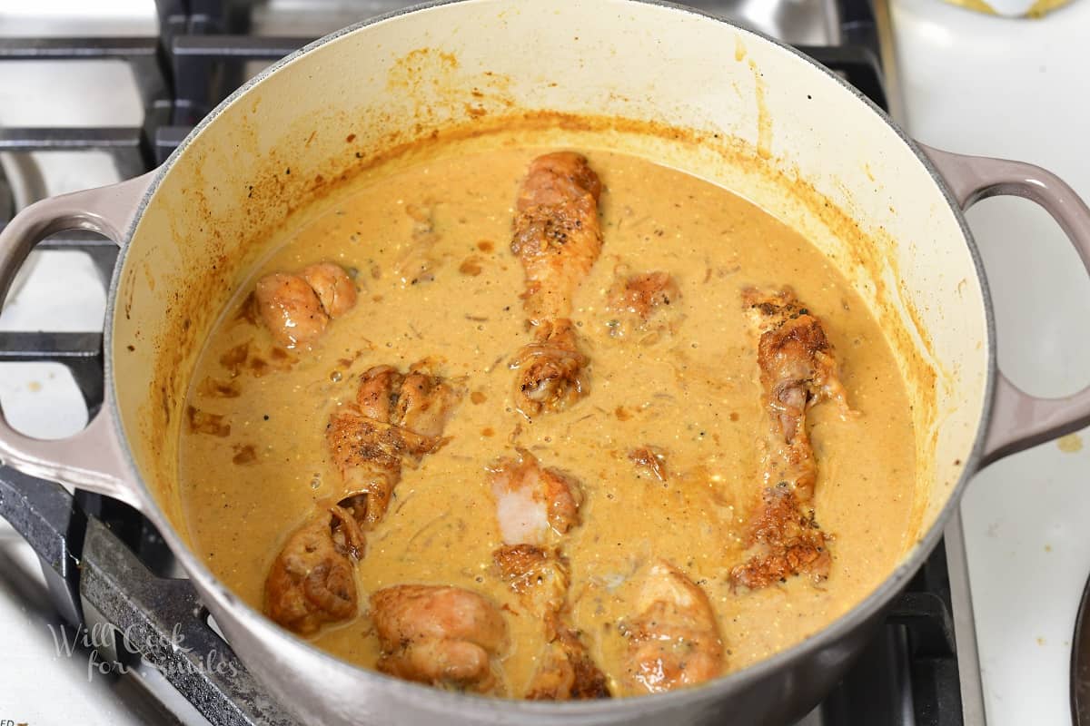 cooked chicken drumsticks in a creamy brown sauce