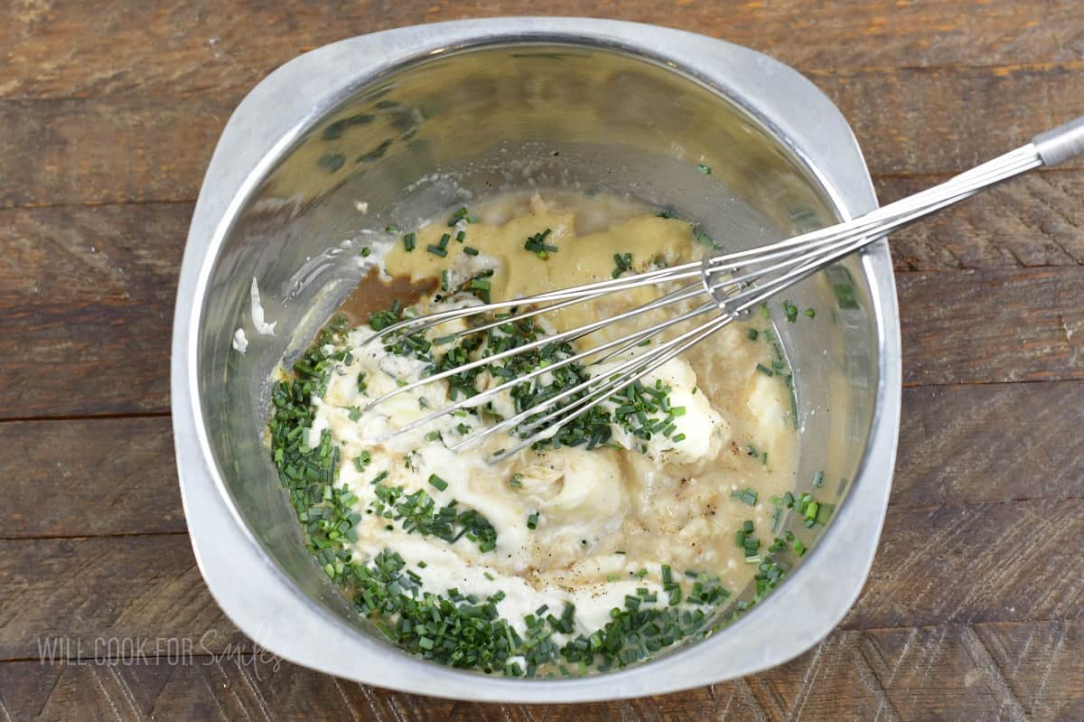 whisking ingredients for horseradish sauce in a bowl.